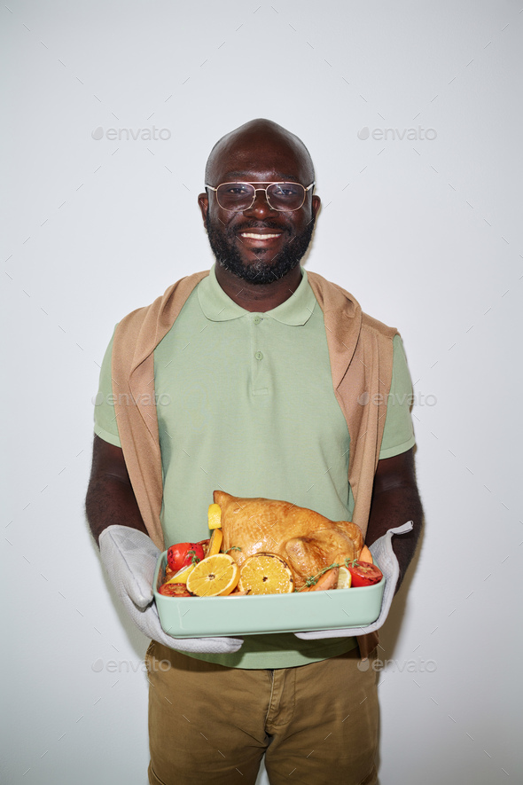 Black Man with Fresh Poultry Dish Against White Background