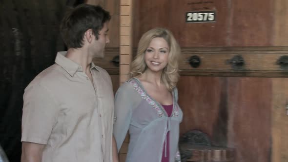 Couple looking at barrel in winery alt