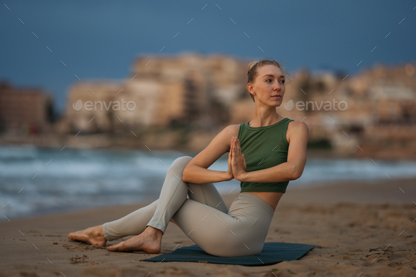 Yoga practitioner engages in a mindful practice by the ocean.