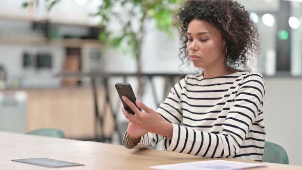 African Woman Using Smartphone in Office alt