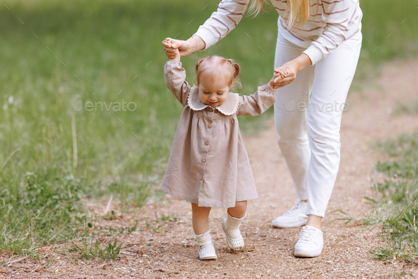 Woman in white clothes have fun with cute child baby girl 1 2 year old Stock Photo by kaplickaya