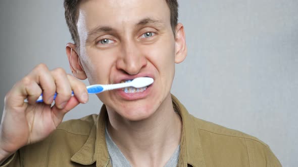 Close Up Head Shot Young Man Brushing Teeth in Bathroom alt