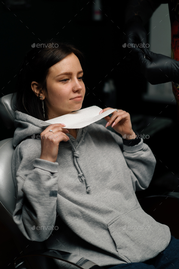 Piercing process Professional nose piercing for a girl the master pierces the nose with needle