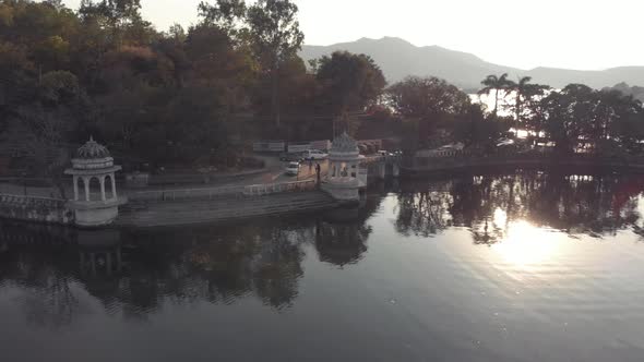 Road along Pichola lake, Udaipur. Amazing architecture and nature.Sunbeam during sunset. alt