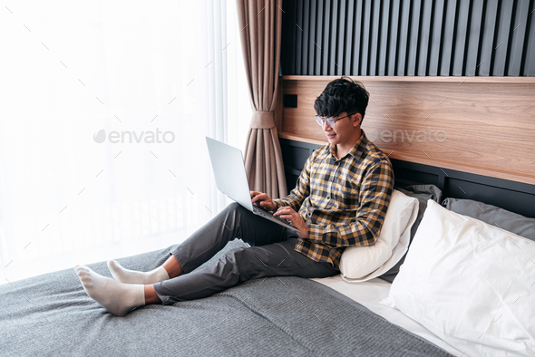 Asian man is looking on laptop screen to checking social media a