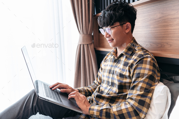 Asian man is looking on laptop screen to checking social media a