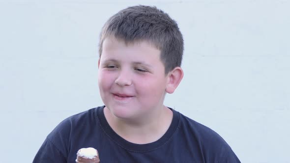 Little Fat Boy Eats Ice Cream on the Street