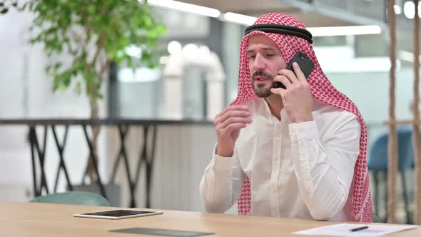 Cheerful Arab Businessman Talking on Smartphone alt