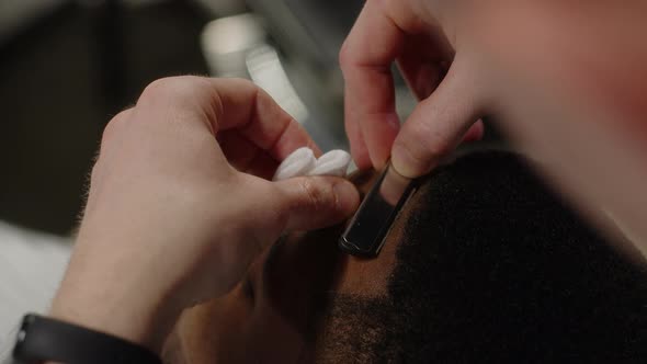 The Barber Shaves the Contour of the Temple of a Man with a Dangerous Razor