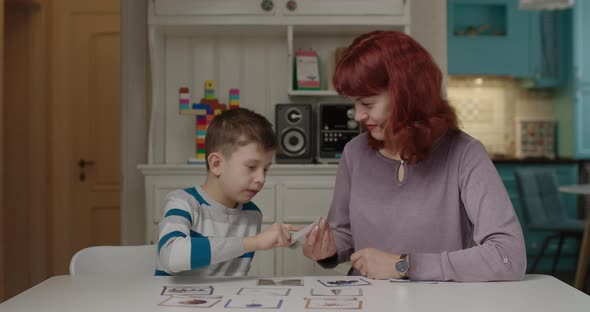 Autism Therapist Working with Kid with Autism To Practice Skills in Reading alt