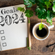 New year goals 2024 on desk. 2024 resolutions list with notebook, coffee cup on table - PhotoDune Item for Sale