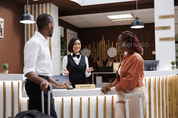 Asian woman helping guests to check in