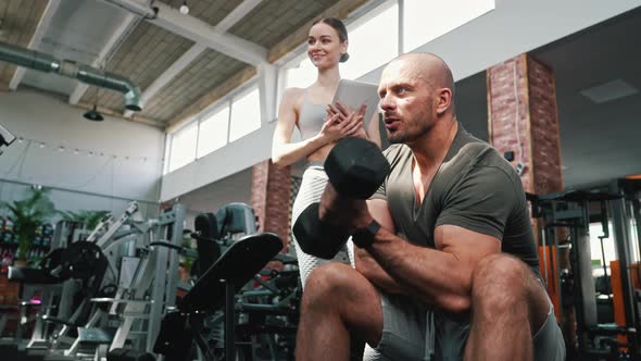 Indoor Shot at a Wellequipped Gym of a Focused Muscular Caucasian Guy Wearing a Sportive Outfit alt