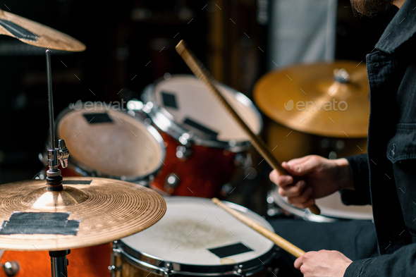 male drummer plays a drum kit in a recording studio at a professional musician\'s rehearsal recording