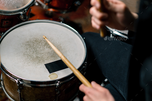 male drummer plays a drum kit in a recording studio at professional musician\'s rehearsal recording