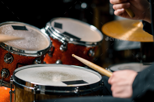 male drummer plays a drum kit in a recording studio at a professional musician\'s rehearsal recording