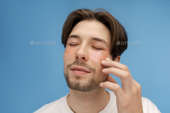 Attractive Metrosexual Man With Eyes Closed Applying Eye Patches Touching Face Isolated Stock 6652