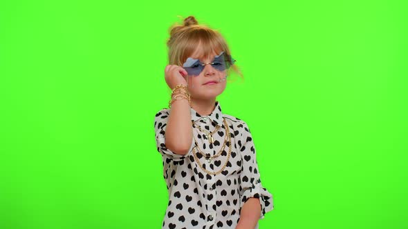 Playful Happy Kid Girl in Sunglasses Blinking Eye Looking at Camera with Smile Winking Flirting alt