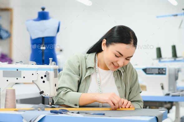 Portrait of a beautiful seamstress carrying a tape measure and