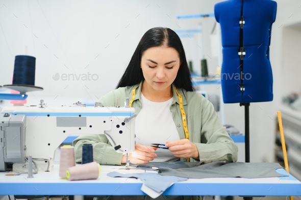 Portrait of a beautiful seamstress carrying a tape measure and