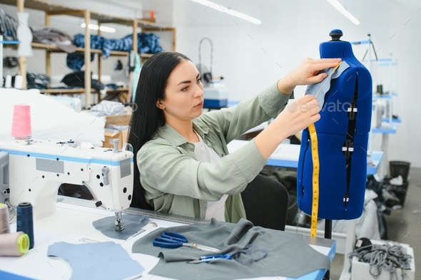 Portrait of a beautiful seamstress carrying a tape measure and