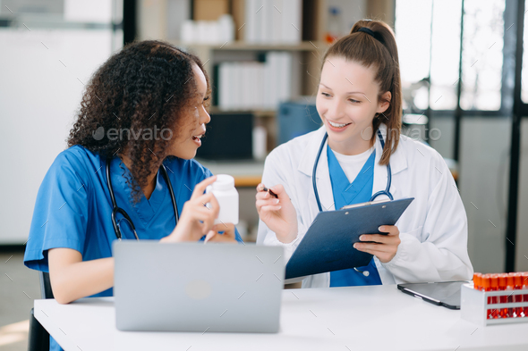 Doctor Talks With Professional Head Nurse or Surgeon, They Use Digital tablet Computer.