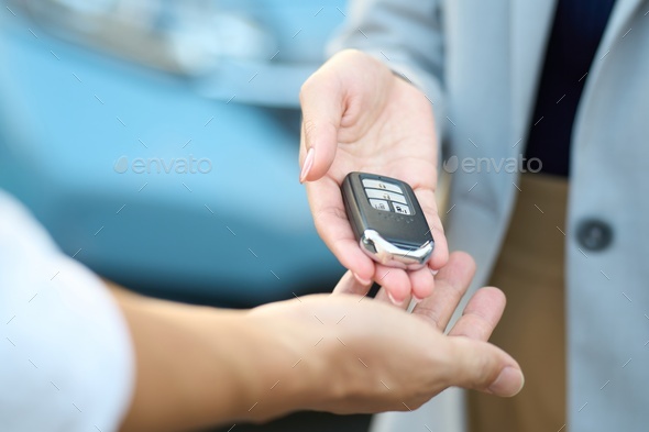 Woman handing over car keys outside