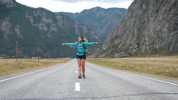 Happy Female Tourist With Backpack Is Turning On Place In Mountains Background alt