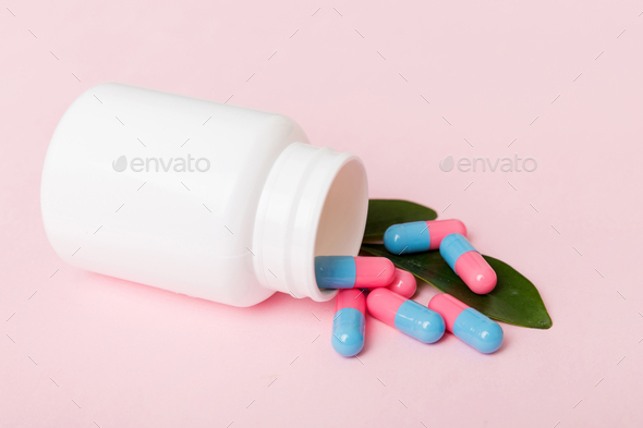 different drugs and health supplement pills poured from a medicine bottle health care