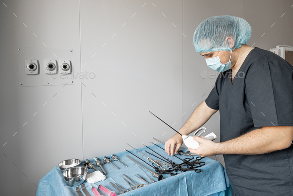 Surgeon takes medical instruments in operating room