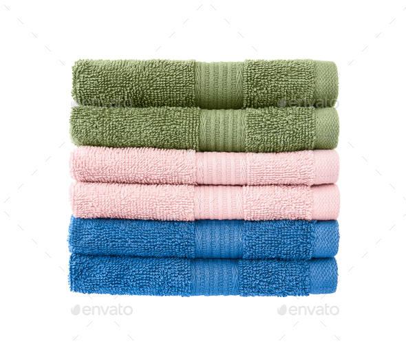 Stack of bath towels on wooden background. White and pink fluffy