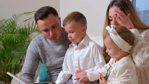 Adorable Family Father Reading a Book to Their Family Sitting in Living Room alt