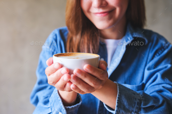 Closeup image of a woman holding a cup of hot coffee Stock Photo by Farknot