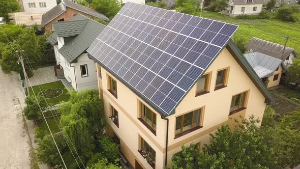 Aerial top view of new modern residential house cottage with blue shiny solar photo voltaic panels alt