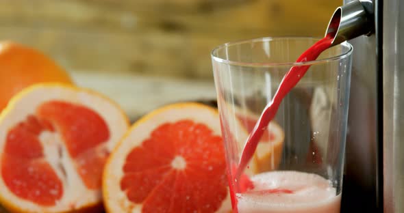 Grapefruit with juice maker on wooden table 4k alt