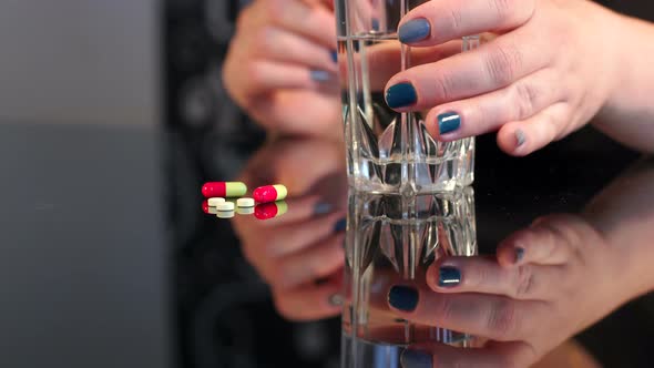 Girl's Takes the Pill and Glass of Water Closeup alt