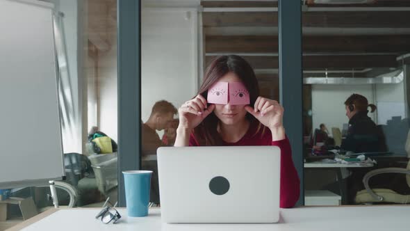 Bored Female Staff Napping at Workplace Covering Eyes with Sticky Notes alt
