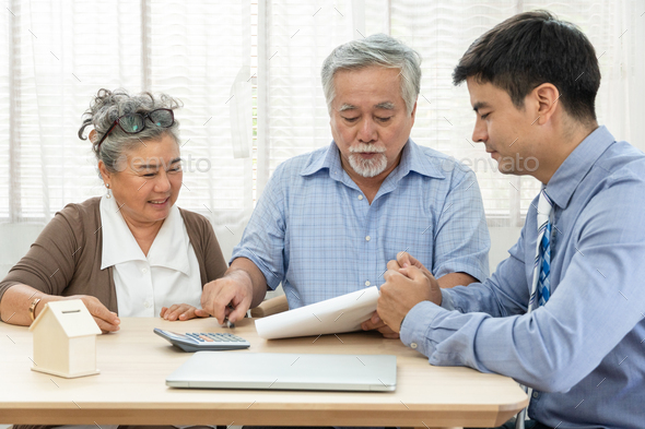 Asian retired senior couple reading property sign contract agreement