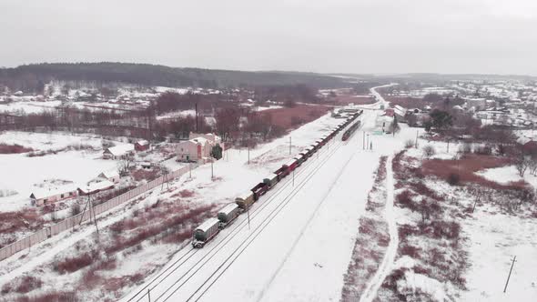 Railway station with railroad tracks and freight train in winter alt