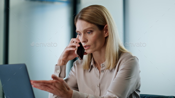 Serious manager discussing phone call closeup. Focused woman pointing laptop