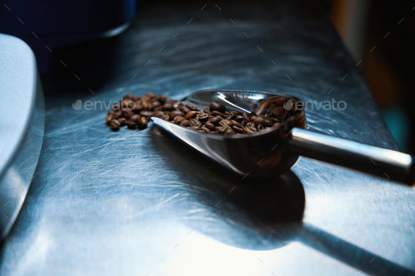 Coffee beans in scoop on coffee house counter copy space
