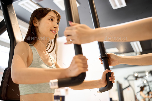 Woman training her chest muscles with a pectoral fly machine Stock Photo by  cait00sith