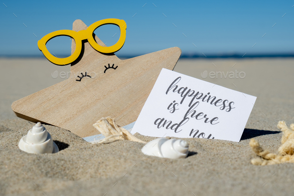 HAPPINESS IS HERE AND NOW text on paper greeting card on background of funny starfish in glasses