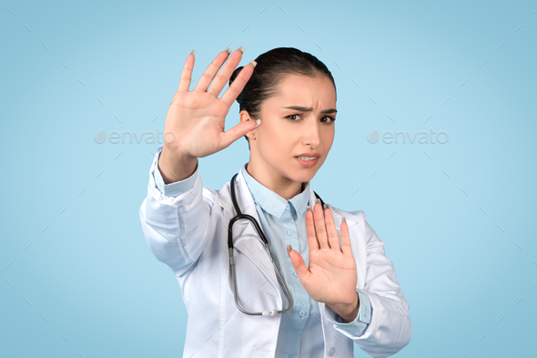 Woman doctor gesturing stop, health precaution sign