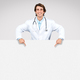 Doctor man pointing down at copy space at blank banner for text or ad Stock  Photo by Prostock-studio