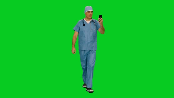 Mid Adult Surgeon In Uniform Having a Videochat While Walking