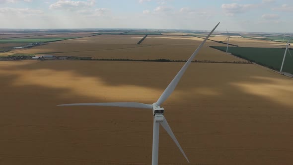 Wind Turbine on a Background of Yellow Wheat Fields Green Meadows on the Banks of the Sea Top View alt