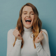 Exuberant young woman in white turtleneck laughing with eyes closed, full of joy and vivacity agains - PhotoDune Item for Sale