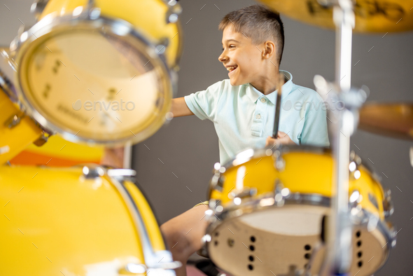 Boy playing on a real drums,