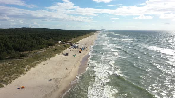 AERIAL: Flying Backwards Above Beautiful Nida Beach with Forest and Sea on Sides alt
